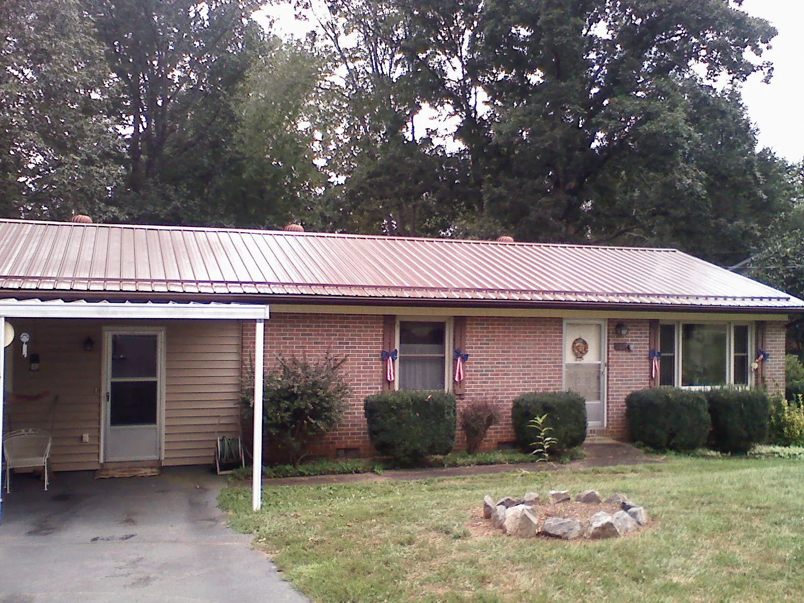 Bronze metal roof and carport on a brick ranch home — Roof Repair work by our crew in Enterprise